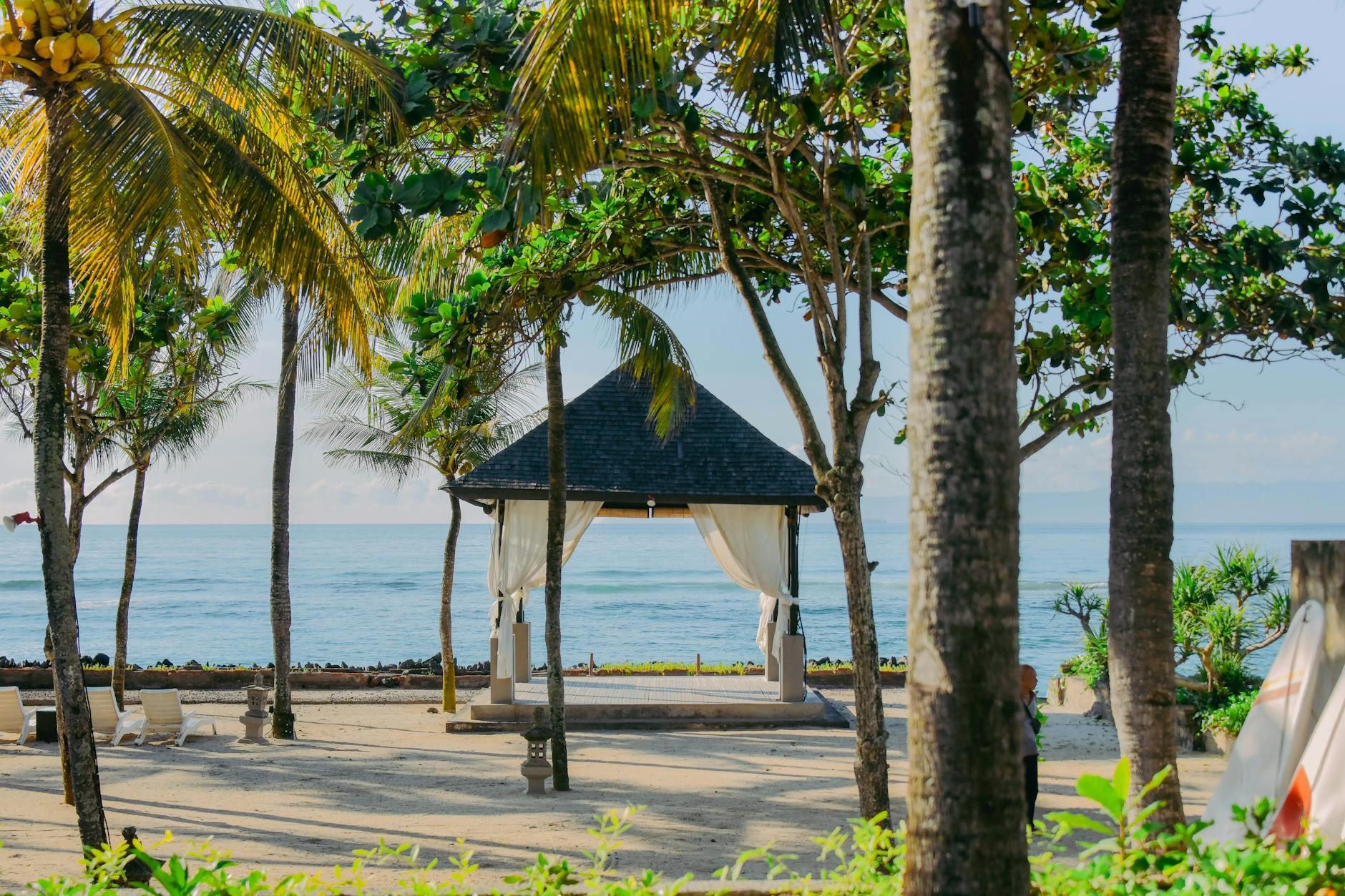 Mobil manual biru melaju di jalan pantai Bali, pilihan tepat rental mobil manual Bali