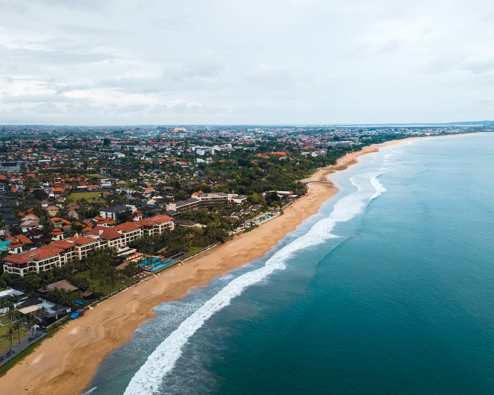 Innova Reborn putih di jalan pantai Bali, layanan rental mobil terpercaya untuk liburan Anda